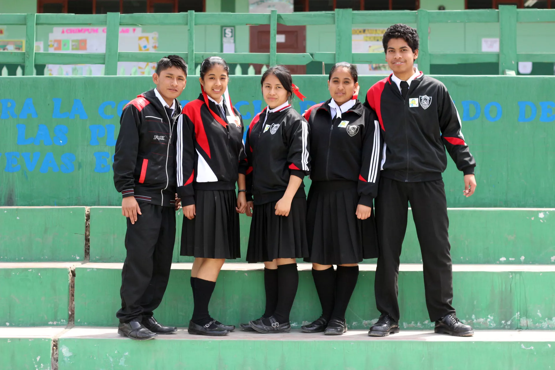 Un grupo de adolescentes de pie dentro de su escuela.