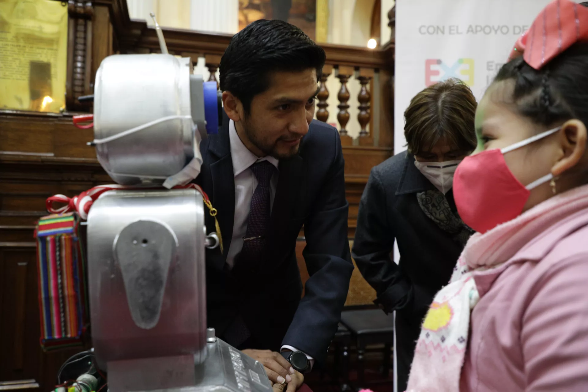Un maestro muestra un robot a una ni&ntilde;a