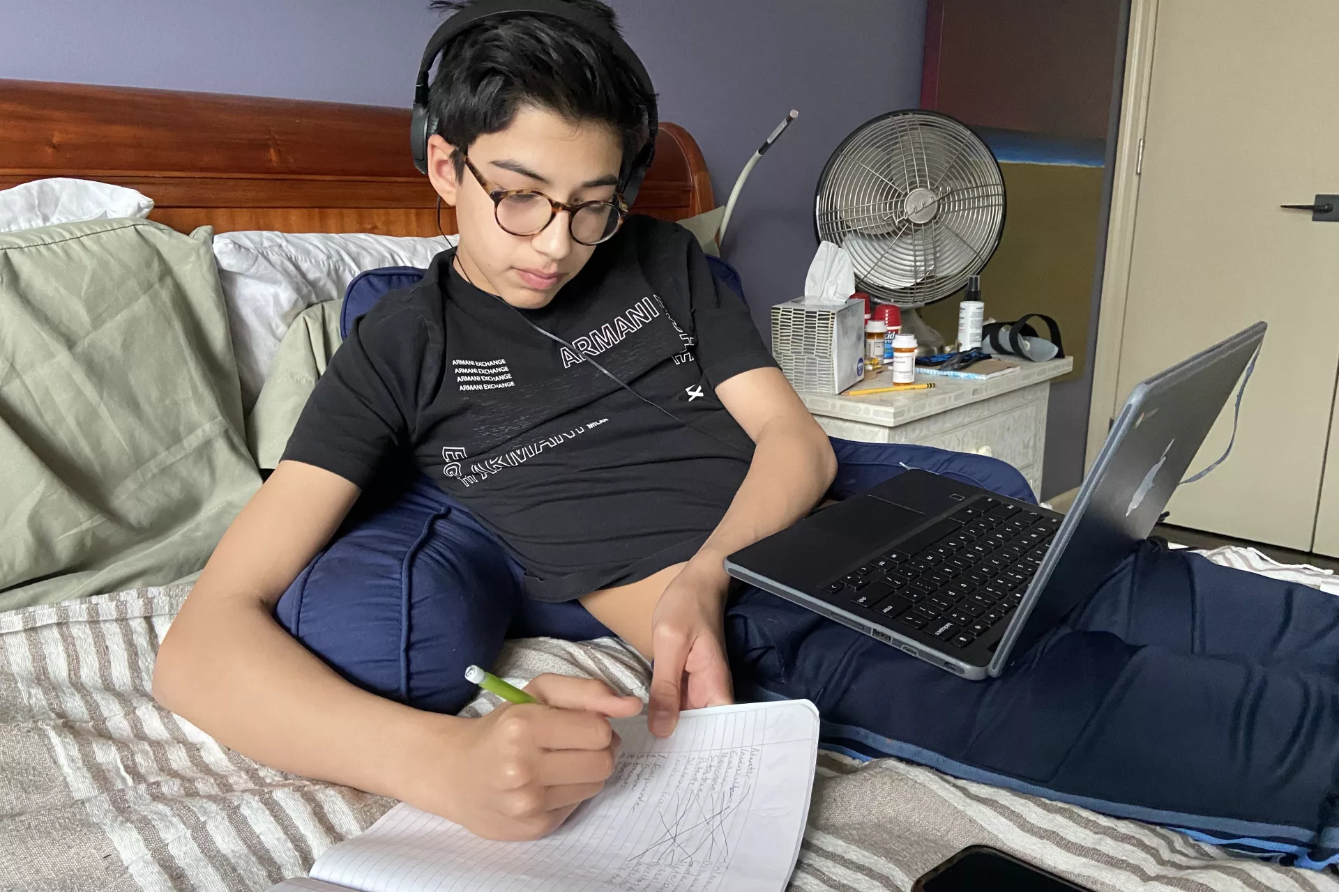 Adolescente estudiando en cama