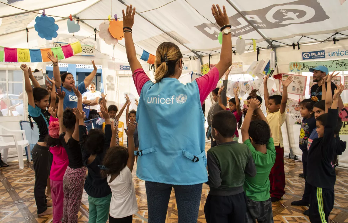 Ni&ntilde;os migrantes jugando en una carpa en Tumbes