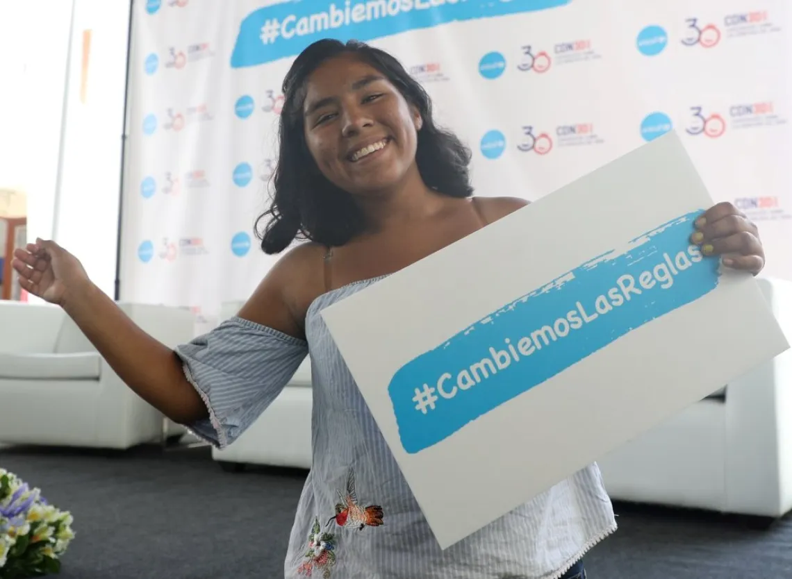 Una adolescente sostiene un cartel en la presentaci&oacute;n de un estudio de UNICEF