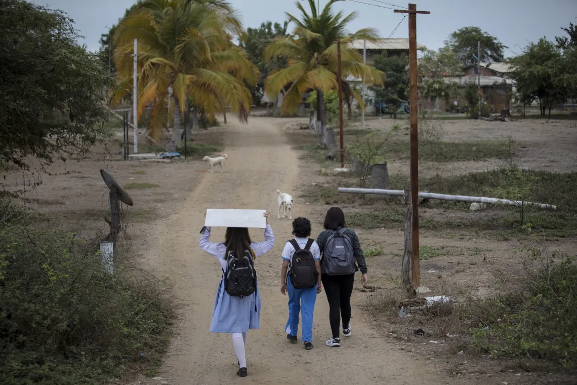 Axlyn caminando a la escuela junto a su hermana y su madre