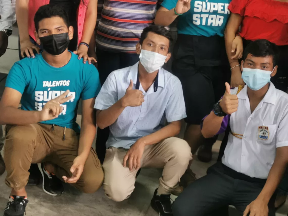 Tres adolescentes sentados saludando a la c&aacute;mara