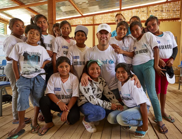 gian marco posando con un grupo de ni&ntilde;os dentro de un aula en Piura