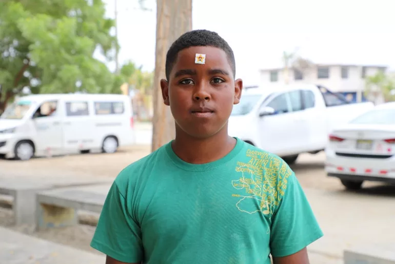 Un adolescente de pie mira de frente a la c&aacute;mara