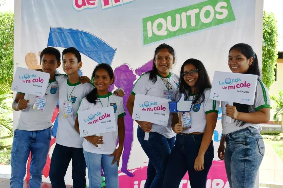 Estudiantes participantes posando frente a cartel de LODMC en Loreto
