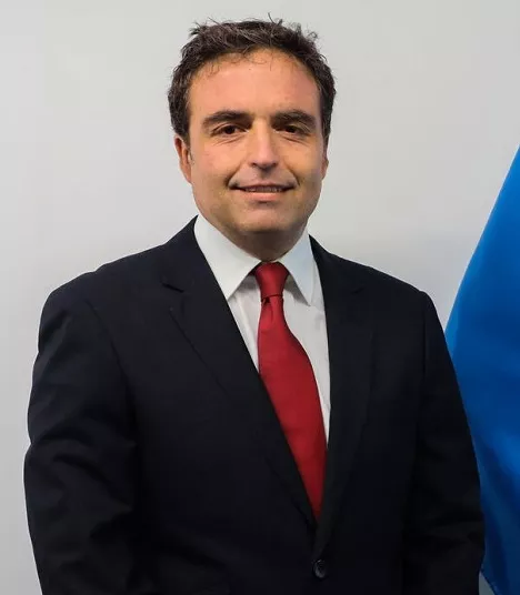 Javier &Aacute;lvarez, Representante, de pie junto a la bandera de UNICEF