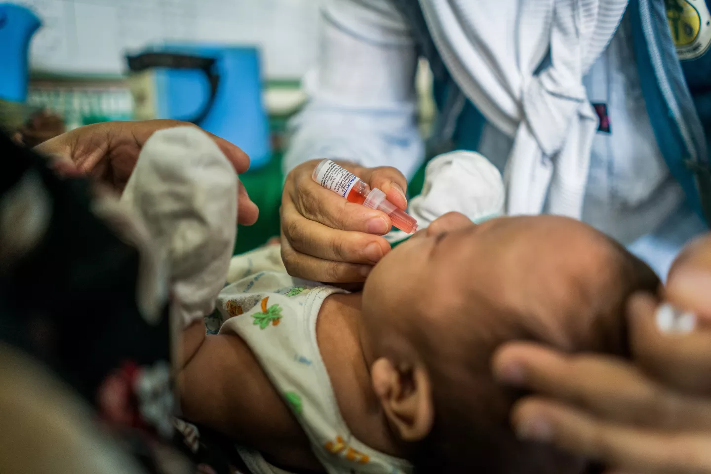 A child receives a dose of oral polio vaccine