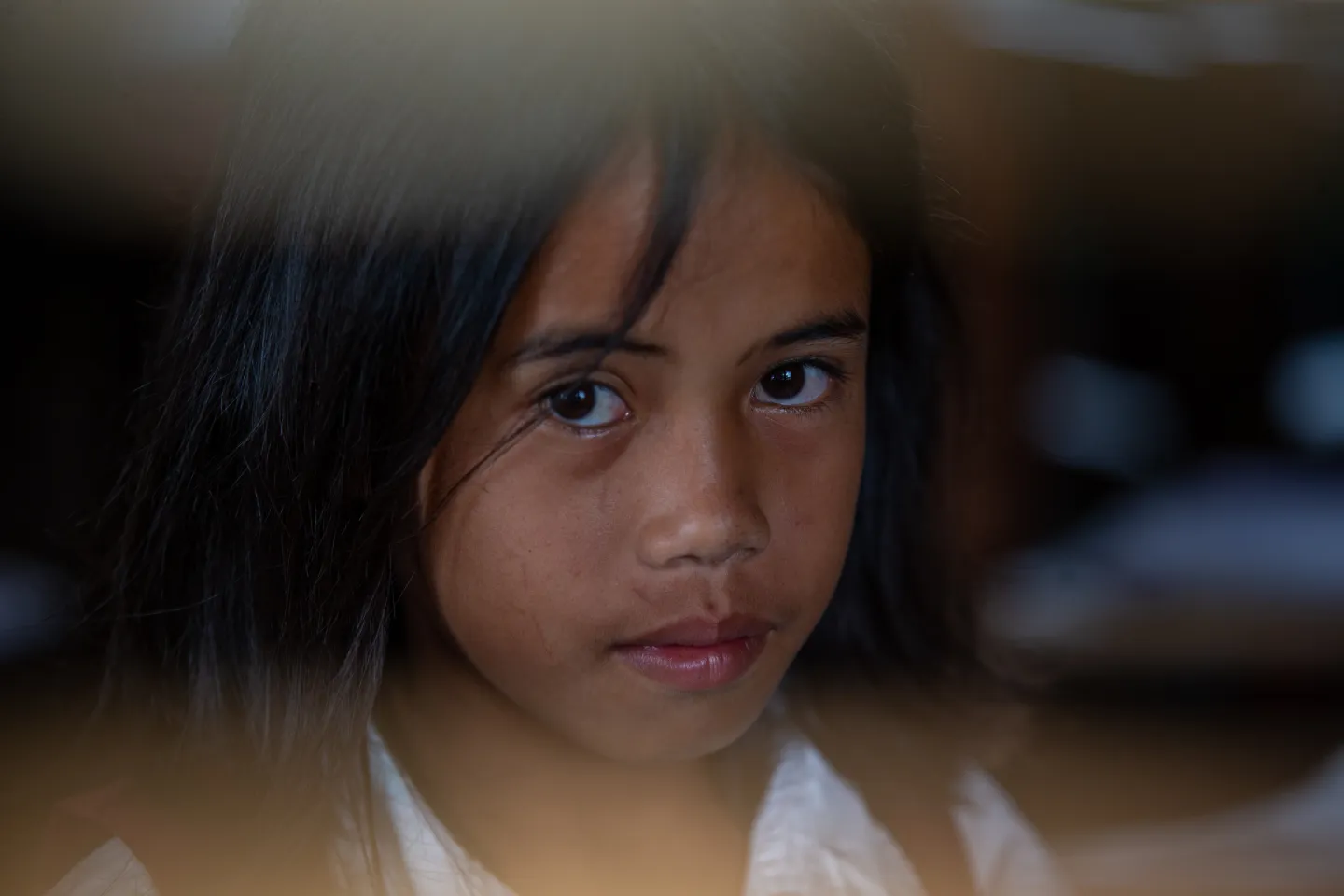 A girl wearing a school uniform looks at the camera