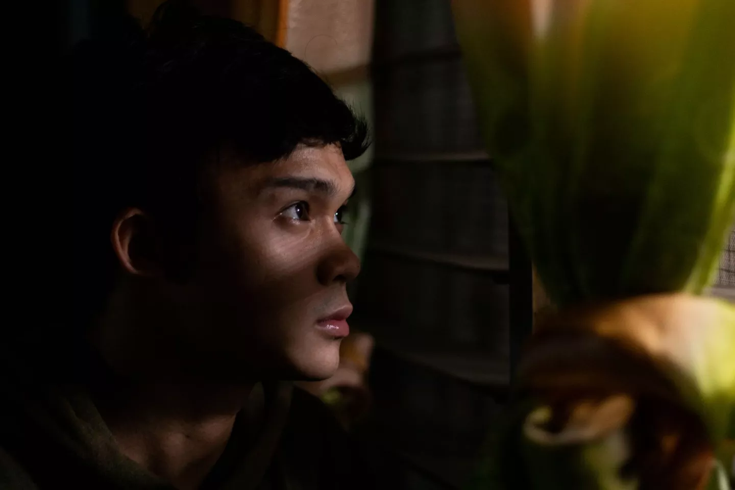 Daniel peers out the window at his home in Cebu, Philippines