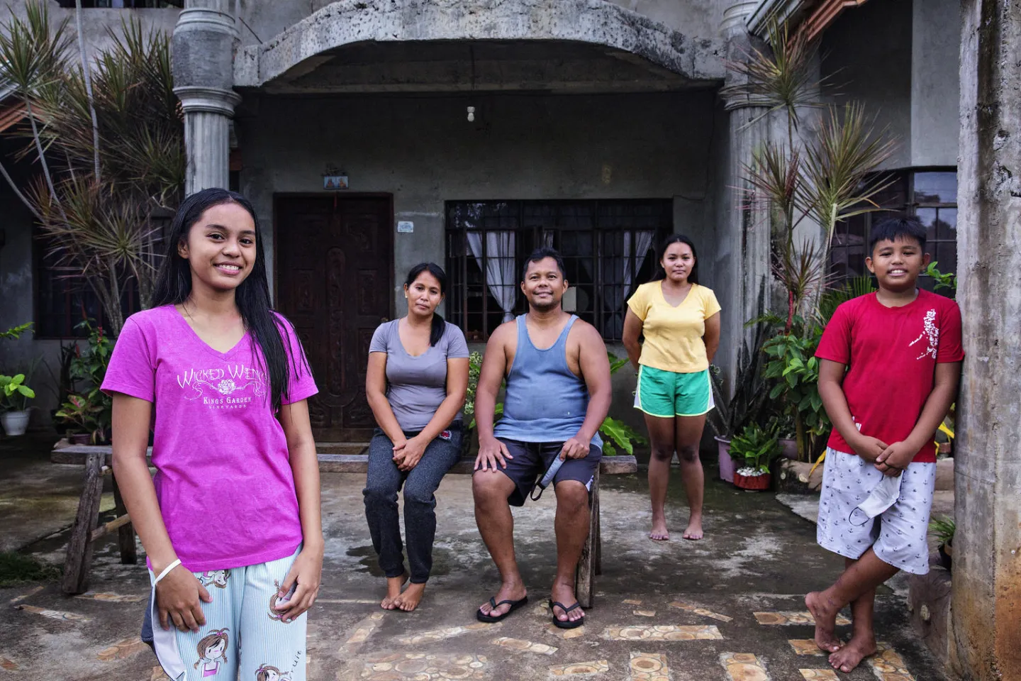 The Loreniana family poses for a portrait outside their house.