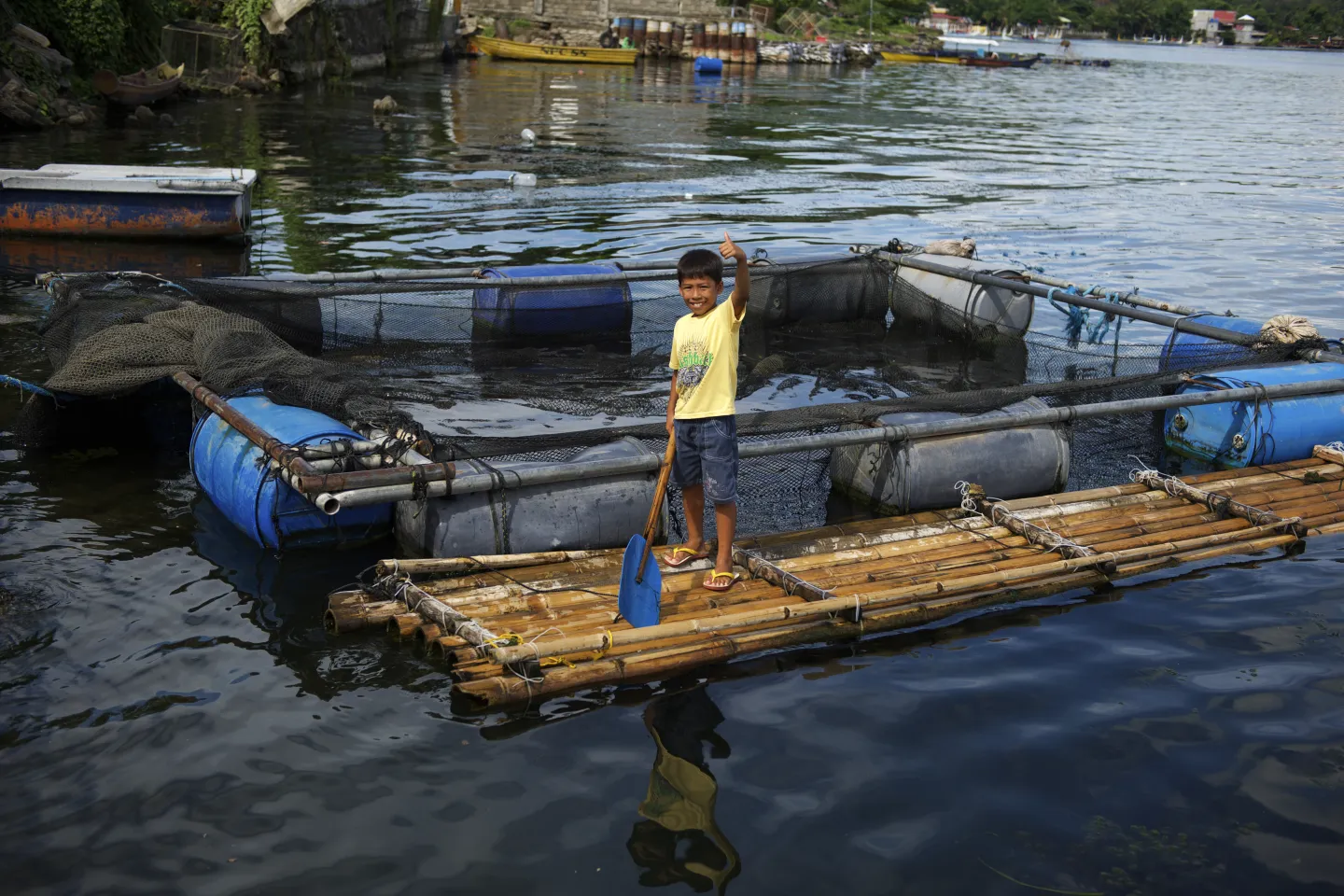 A boy stands on a raft floating in a lake