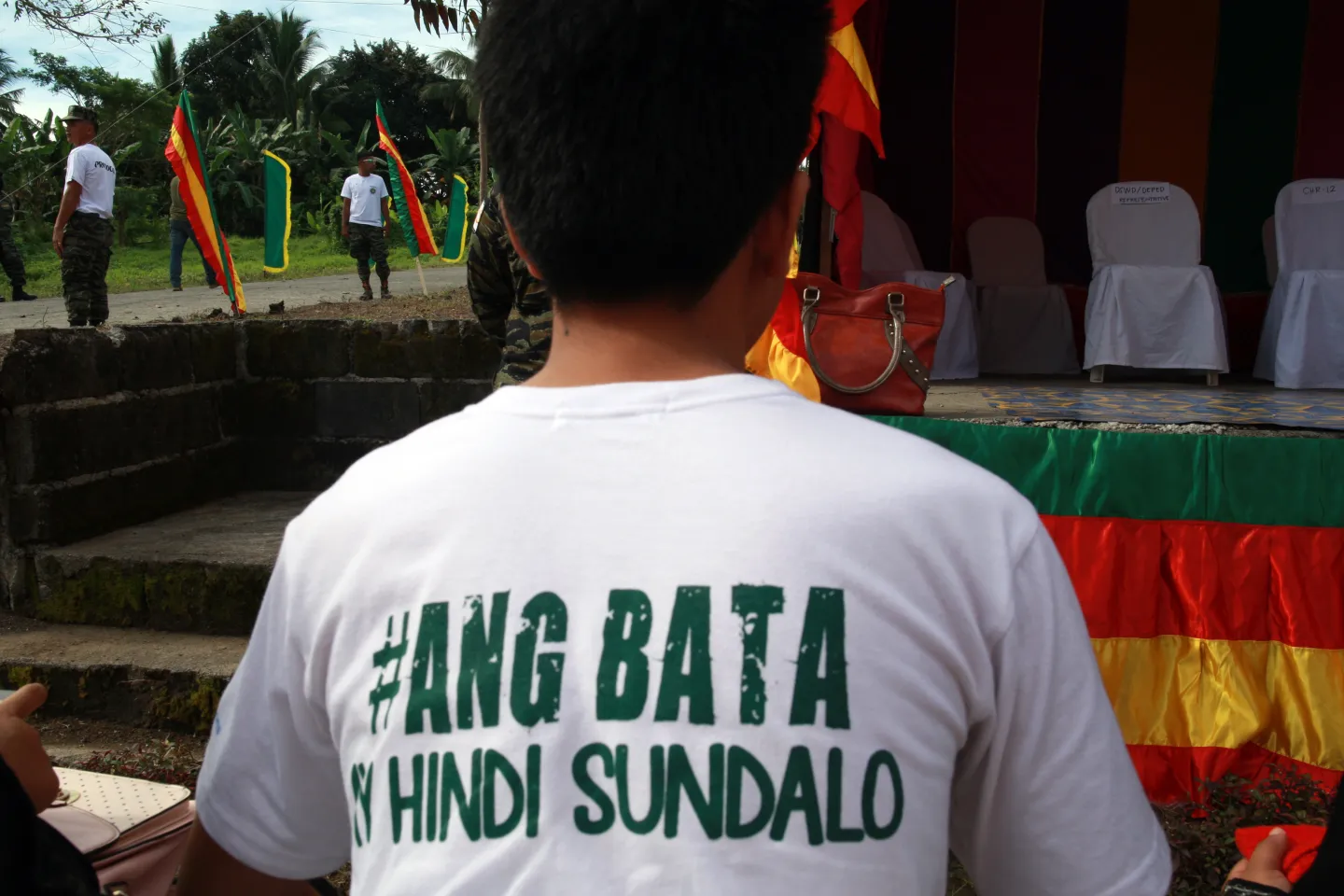 A boy, his face not visible, wearing a t-shirt with the campaign hashtag #AngBataAyHindiSundalo (#ChildrenNotSoldiers) printed on the back, attends a disengagement ceremony for children recruited or used by the Moro Islamic Liberation Front in its armed group