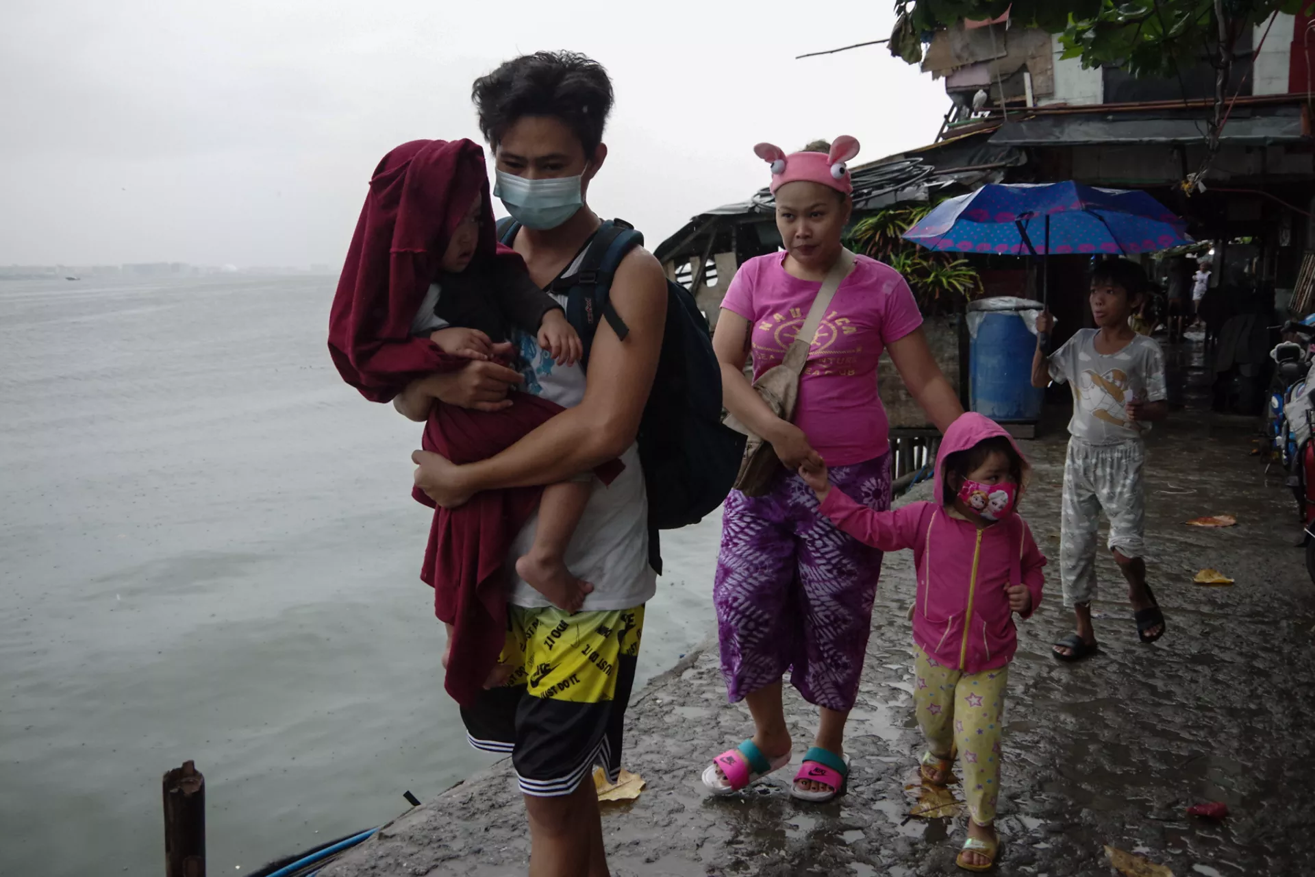 A family leaves their home in Aplaya, Baseco, Manila, to seek shelter in an evacuation center as super typhoon Rolly/Goni hit the Philippines on 1 November 2020