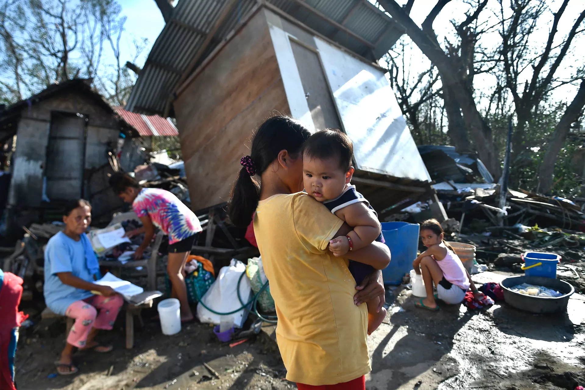 Residents gather next to their destroyed house in Carcar, Philippines' Cebu province on December 18, 2021, days after Super Typhoon Rai hit the city.
