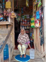 A woman sitting at the front steps of her home