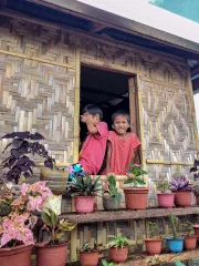 Two boys seated at the window of their house