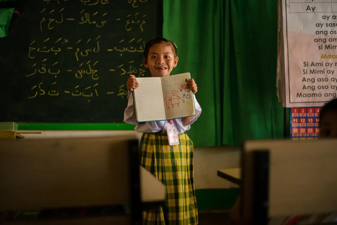 Child from Sumisip, Basilan, shows her drawing, which serves as her message to the future leaders of the Bangsamoro.