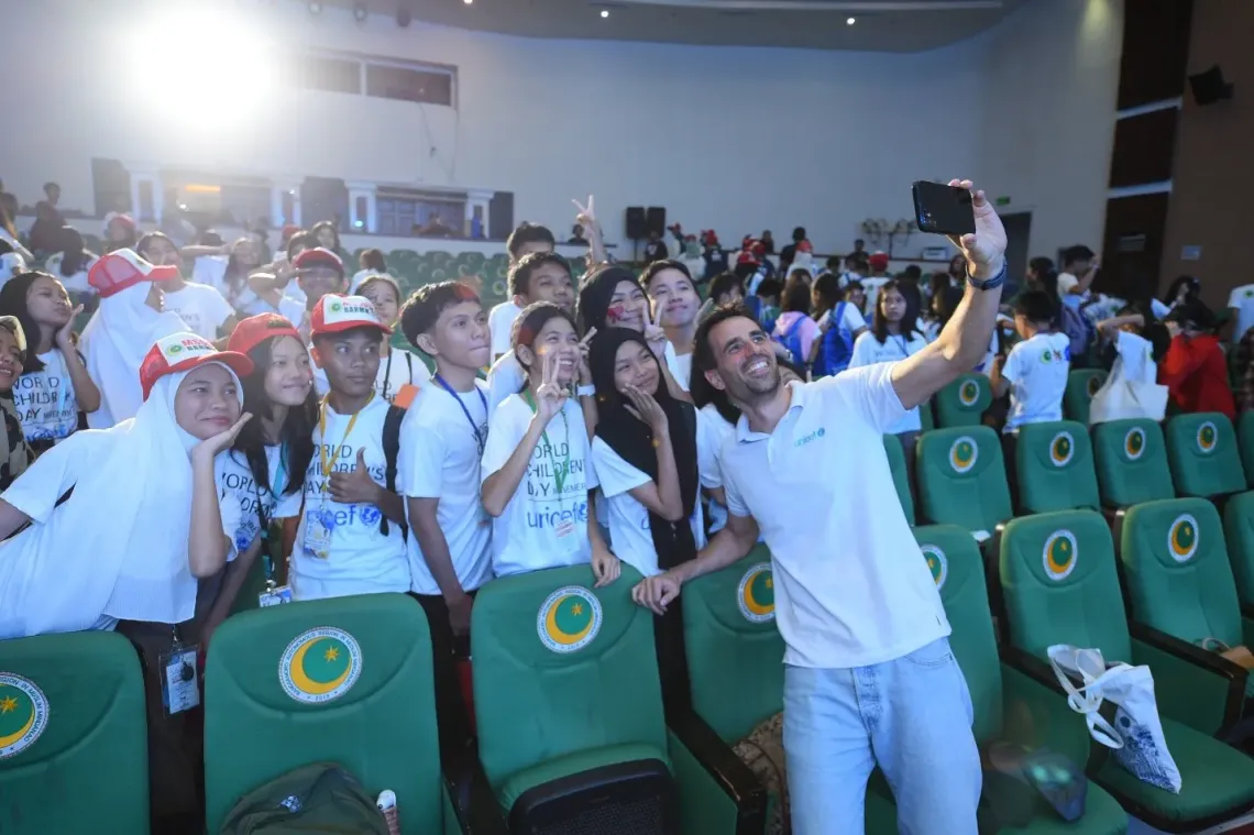 Andreas Wuestenberg, Chief of UNICEF Mindanao Field Office takes a selfie with children during the World Children's Day celebration in 2024. 
