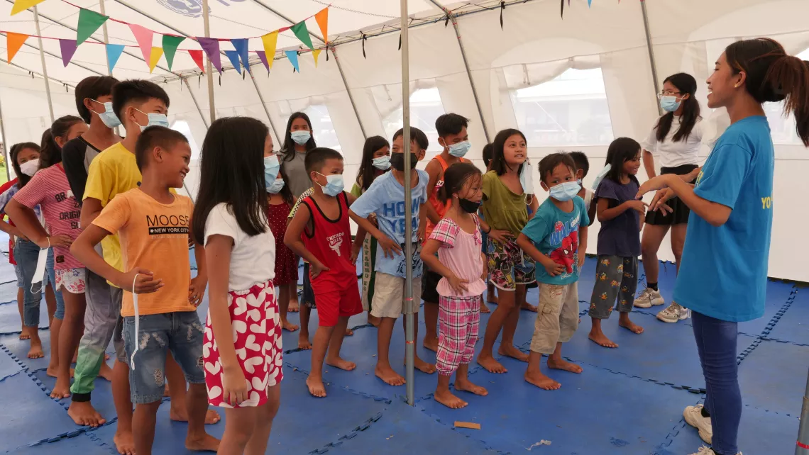 A volunteer facilitates a play activity at a Child Friendly Space