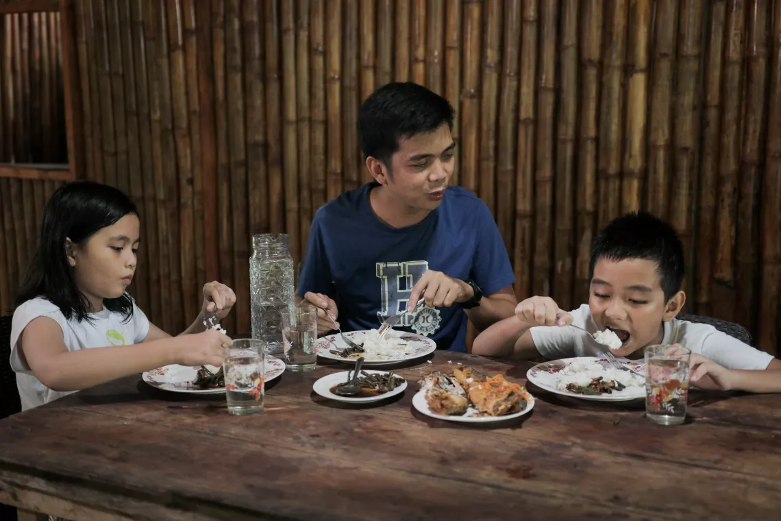 Father and children eating healthy food at home