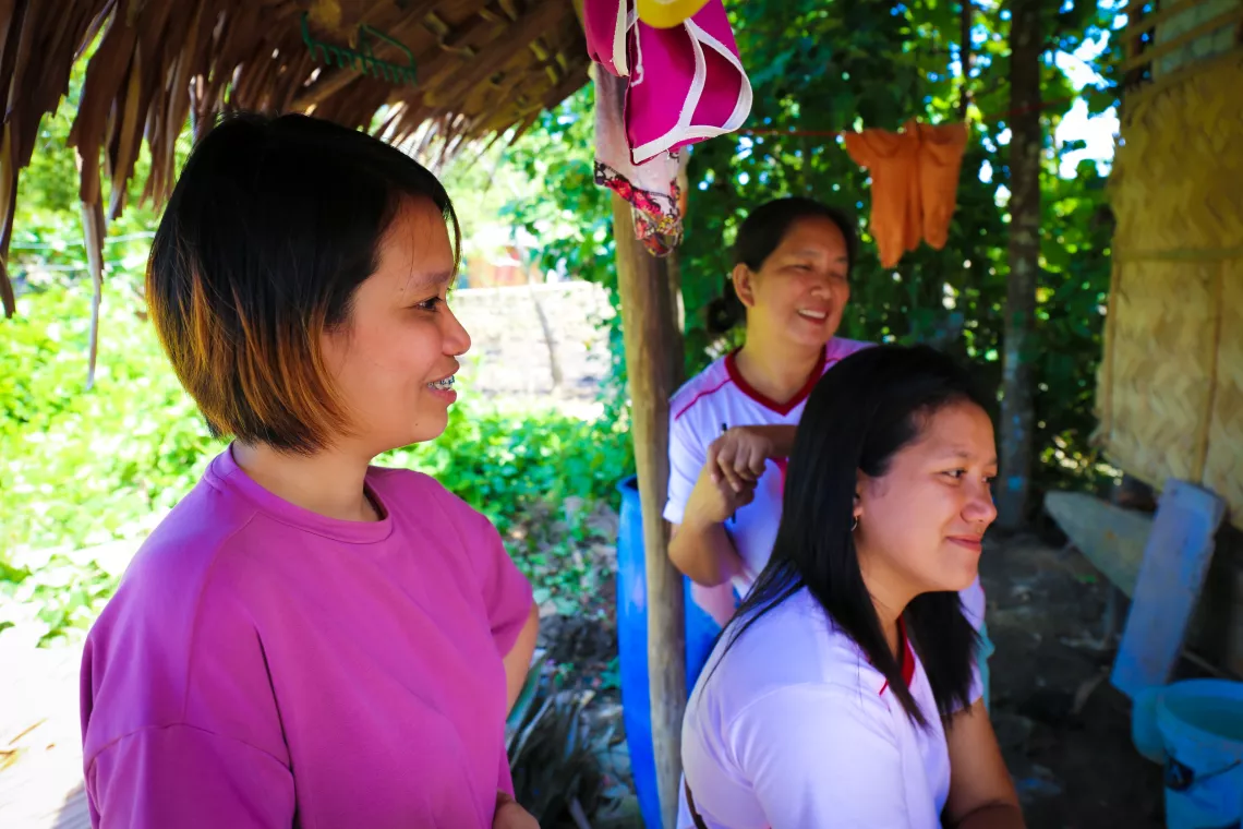 Three health workers talking to a resident not visible in the photo