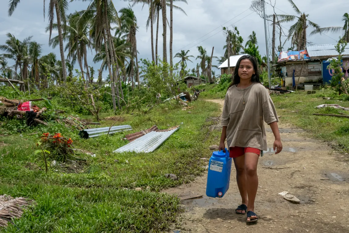 Jasmine trekking to the Water Bladder to refill her family's jerry can 