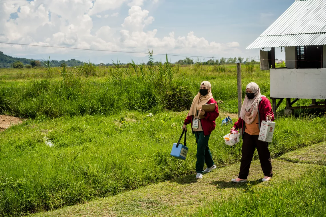 Health workers Ash and Injilah go house-to-house in the communities covered by their Rural Health Unit to offer vaccines.