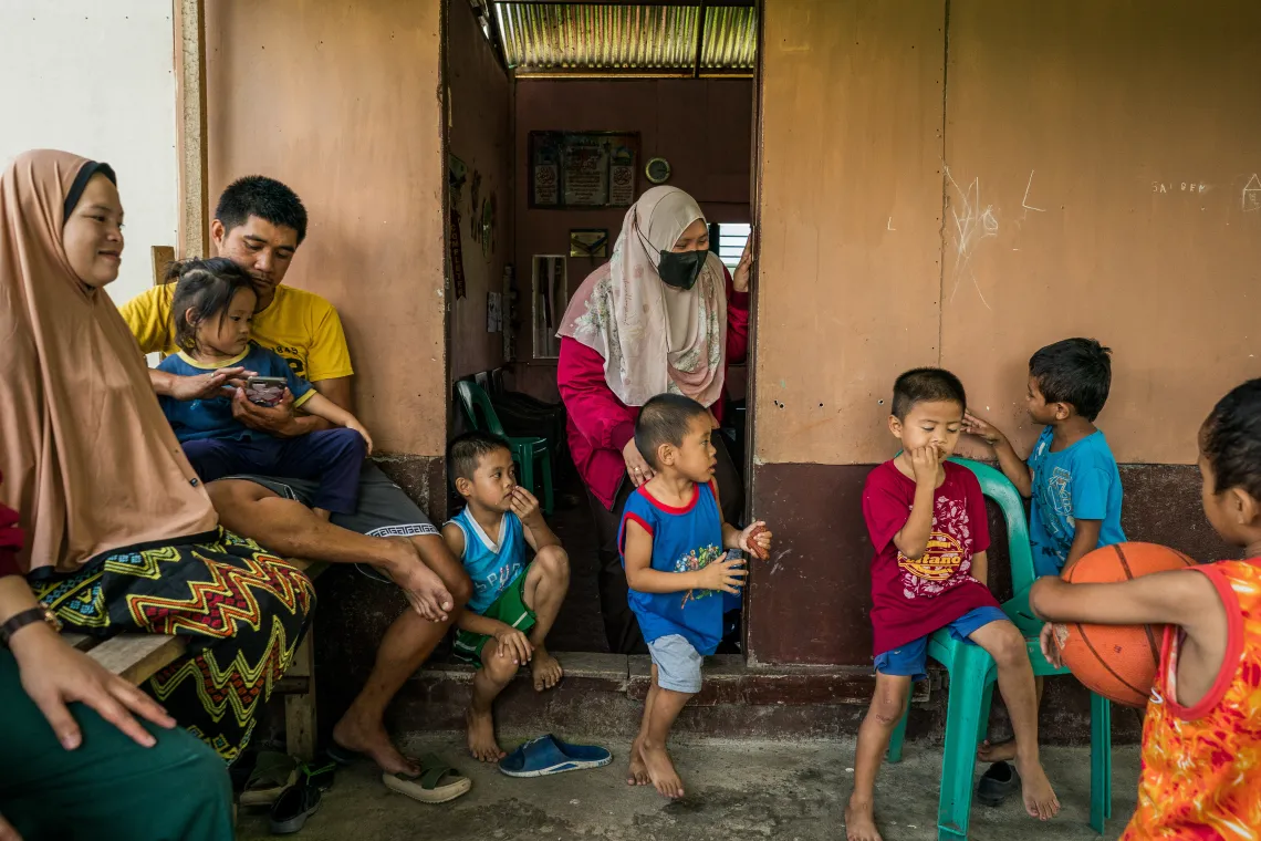 Health worker Ash (center), with Norsainah and Baniamen and their children