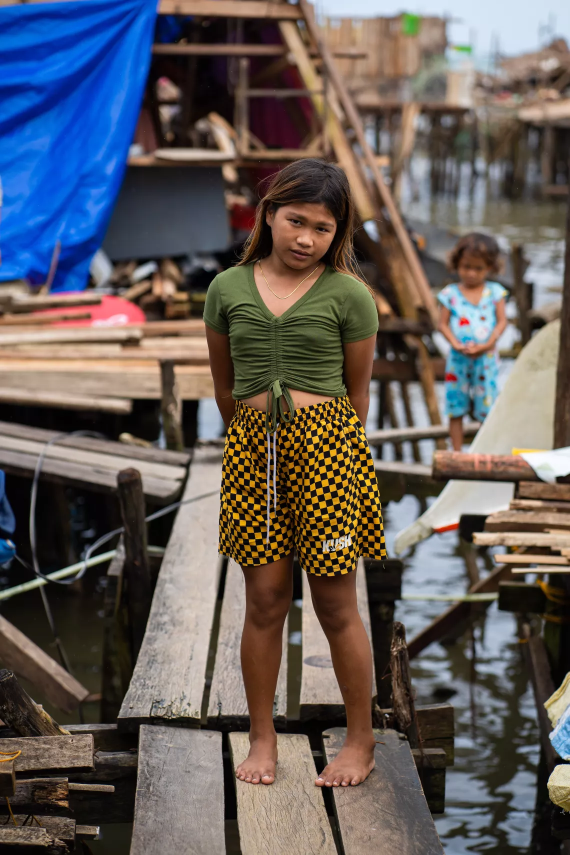 A girl standing on a walkway over water