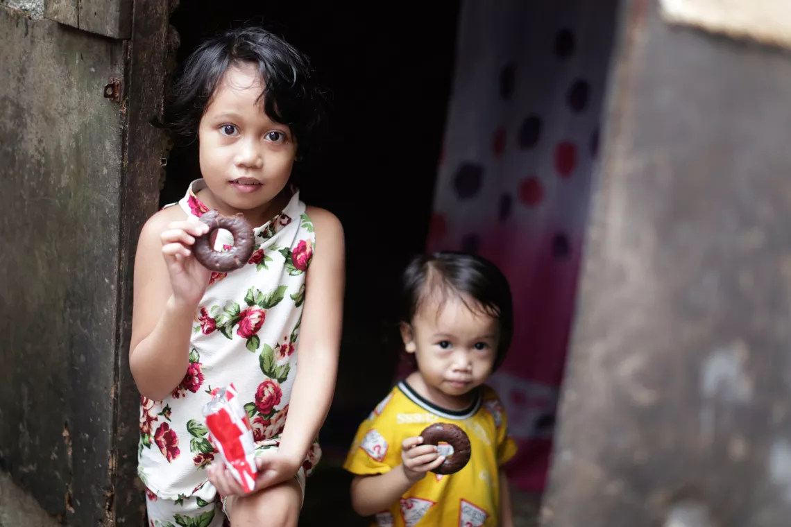 Children enjoy their choco-flavored sugar-coated donut.
