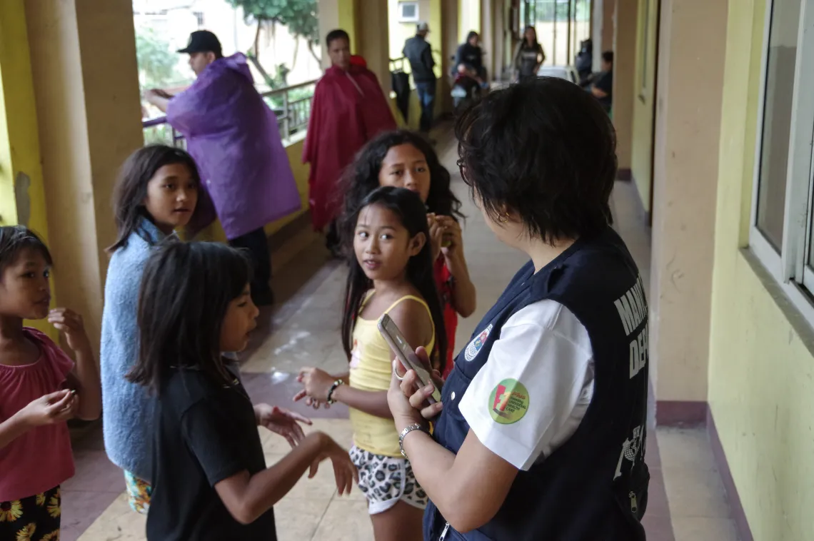A health worker talks to children