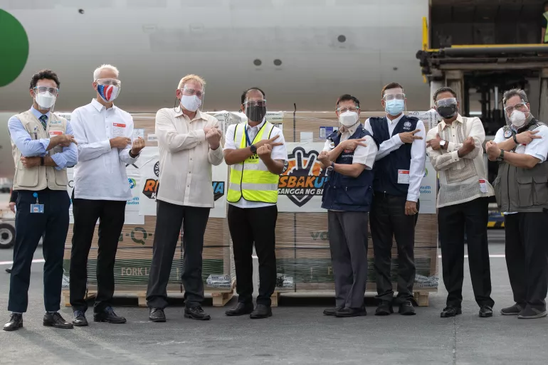 Officials from UNICEF, the Department of Health, the US Embassy in the Philippines, USAID and WHO stand in front of a shipment of COVID-19 vaccines donated by the US Government to the Philippines via COVAX