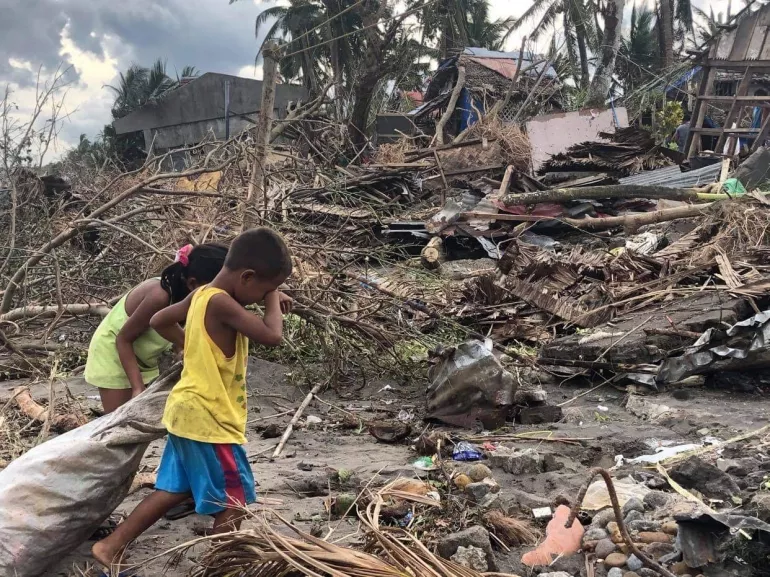 Siblings go around Barangay (village) Sabang, San Jose, in Camarines Sur province, Philippines, to find items that they can salvage in the aftermath of typhoon Rolly (Goni)