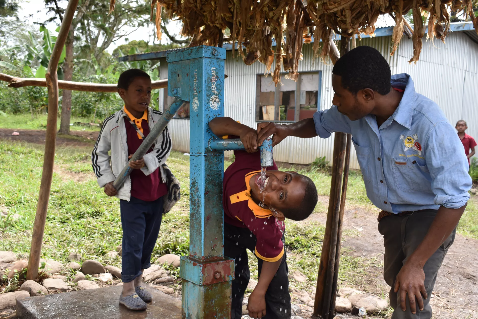 Children drinking water from a UNICEF water pump.