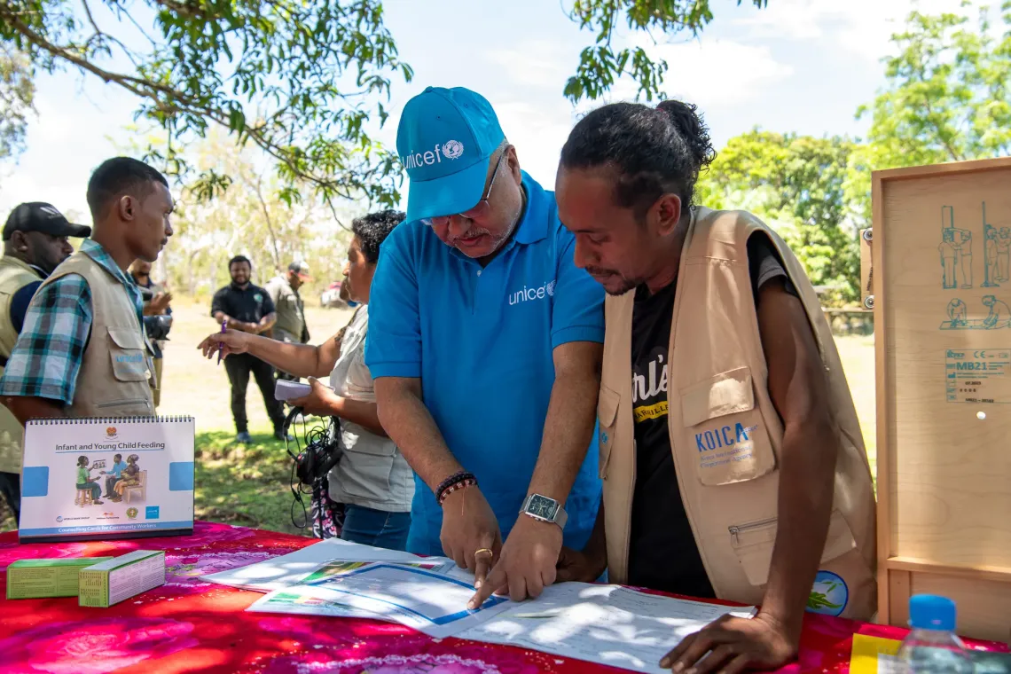 UNICEF Representative Vikas Singh reviews a health chart with Rabona, a trained Village Health Assistant in Boregaina Village..
