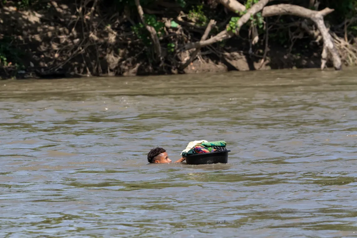 Hundreds of students students cross the river like this everyday - using a dish to keep their uniform and books dry 