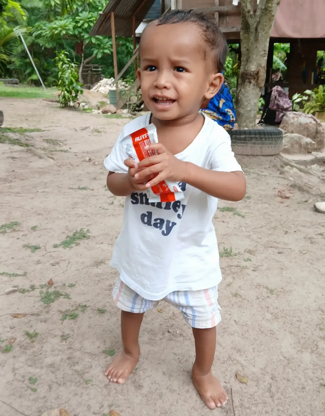 Vali, 3, receives his RUTF supply during a monitoring visit