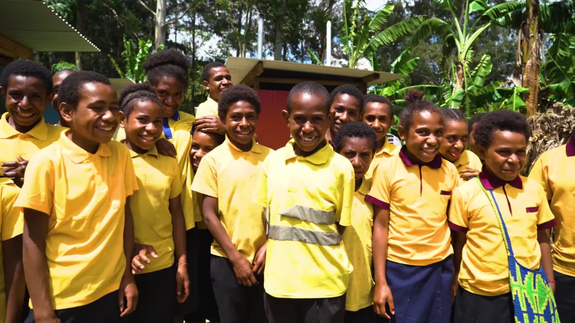 Students standing beside their new toilet block whose facilities they help to maintain