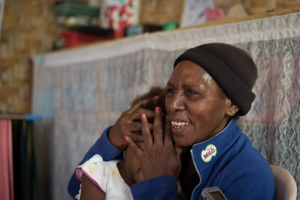 A mother covering her child's eyes.
