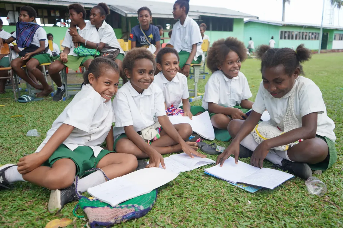 A group of young female students sitting on the lawn