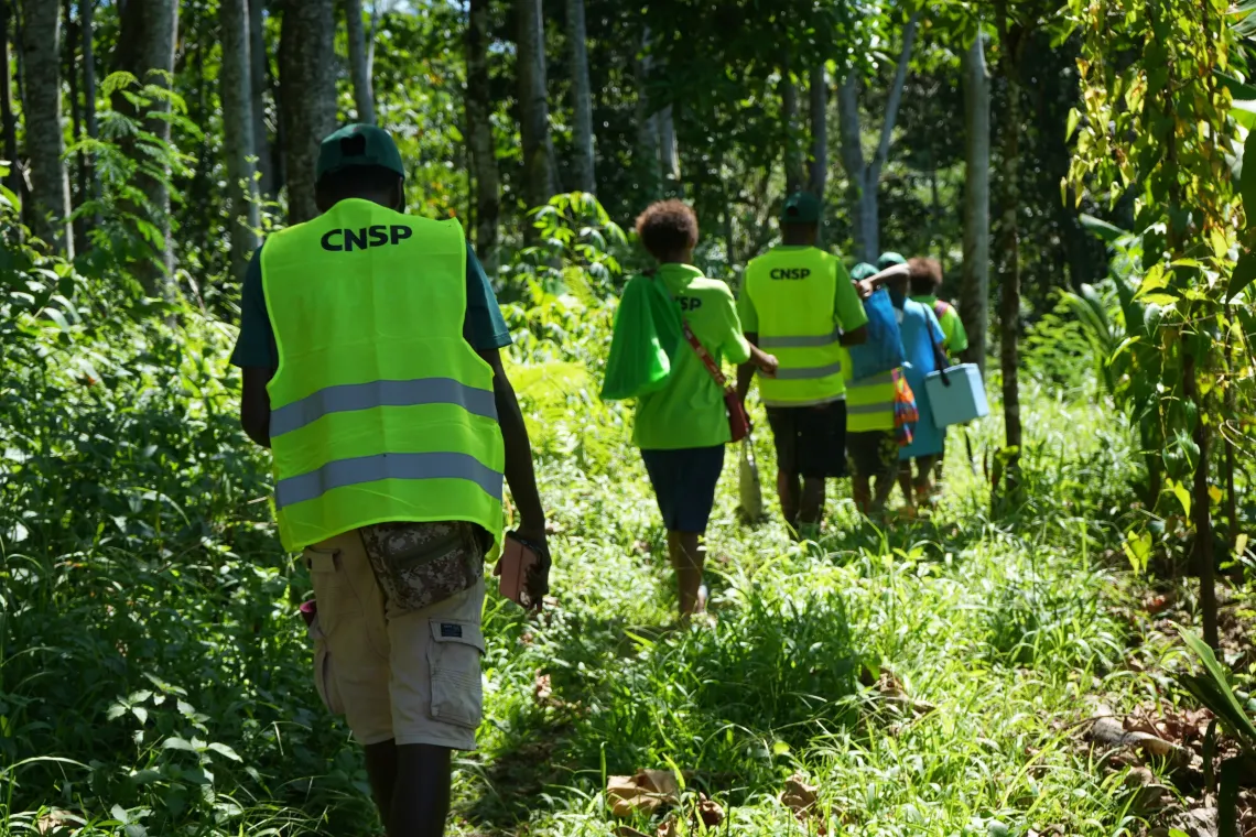 Reaching families in remote hamlets often requires long walks across challenging terrain