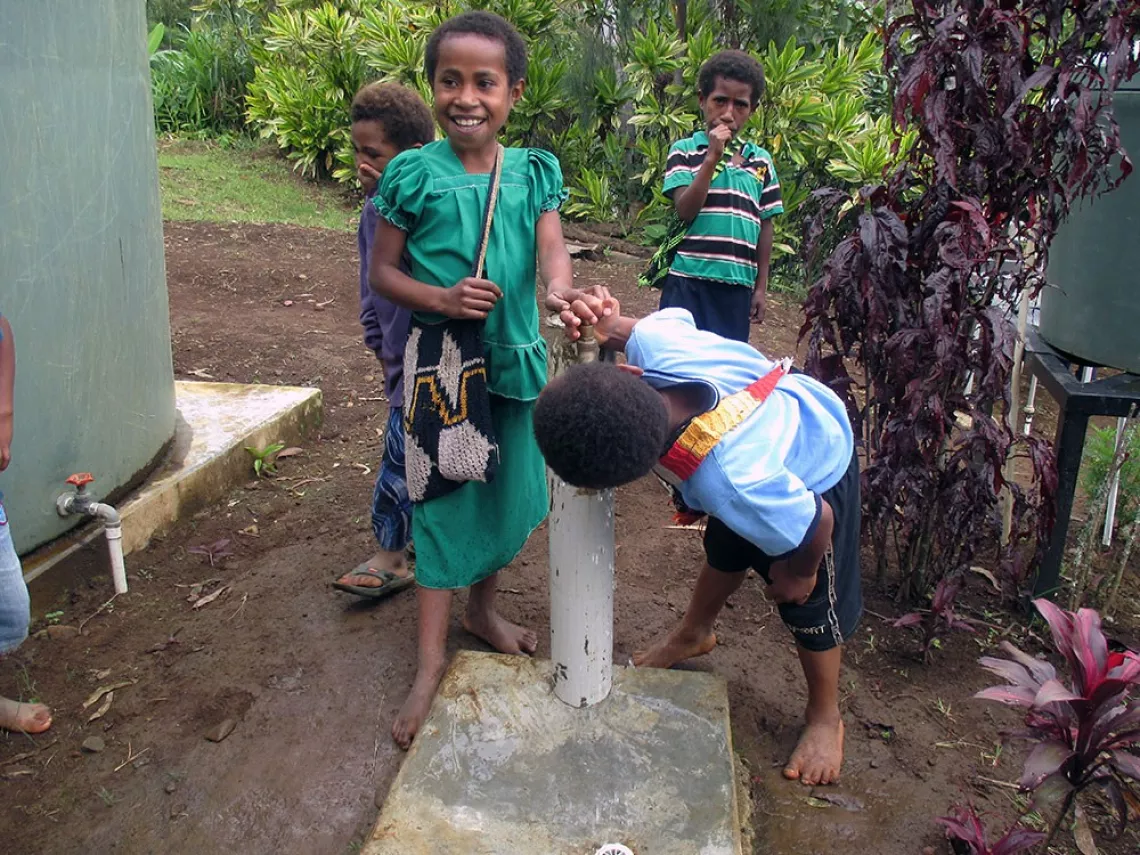 Students drink water from the tank and tap installed by UNICEF