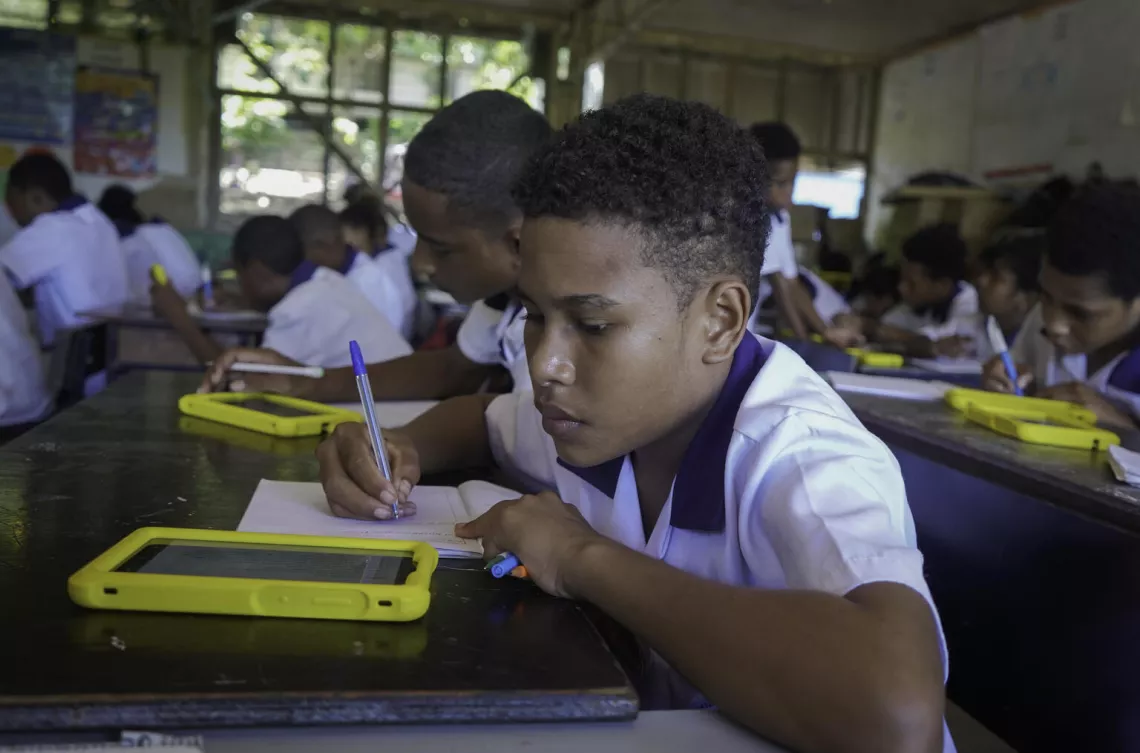 A student from Sevese Morea Primary School using the tablet from the Spark Kit to support his learning.