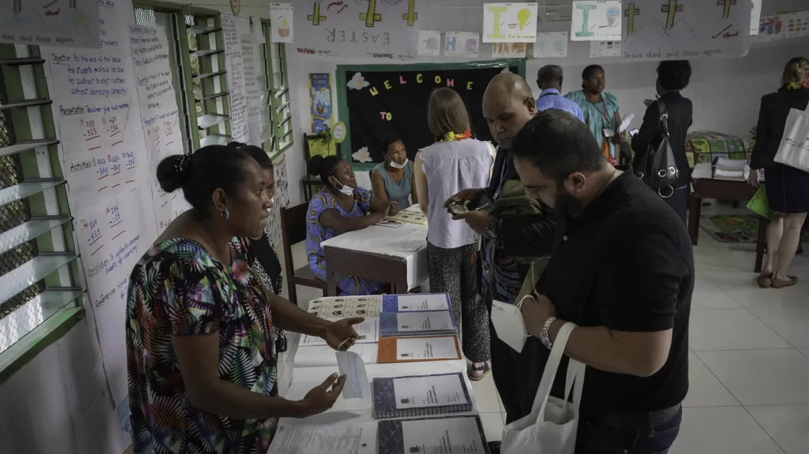 Grade 8 teacher, Fransica Kitawal (left) explains how the Home Learning Pack is used.