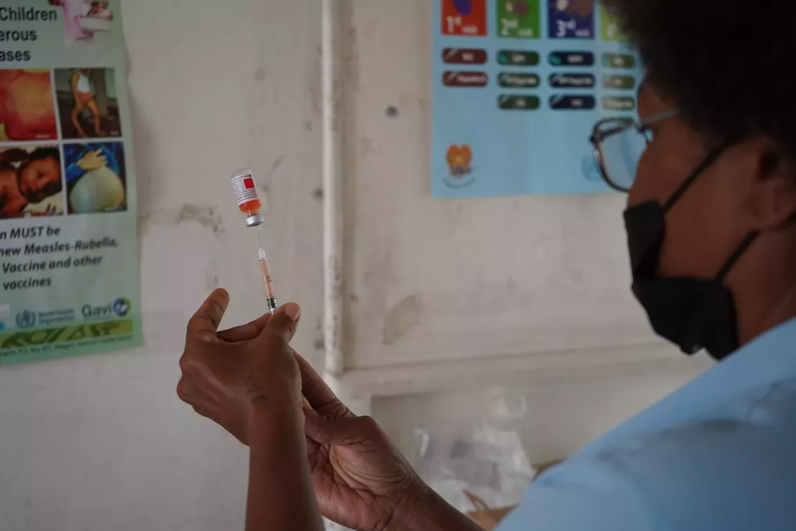 Nurse Agu prepares vaccination shots for the many babies waiting to be vaccinated.