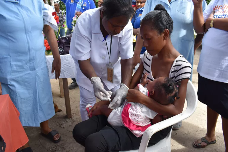A nurse administering polio vaccine to a child.