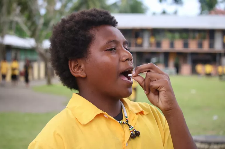 A child taking a pill.