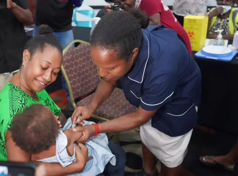 A young child being vaccinated against measles.