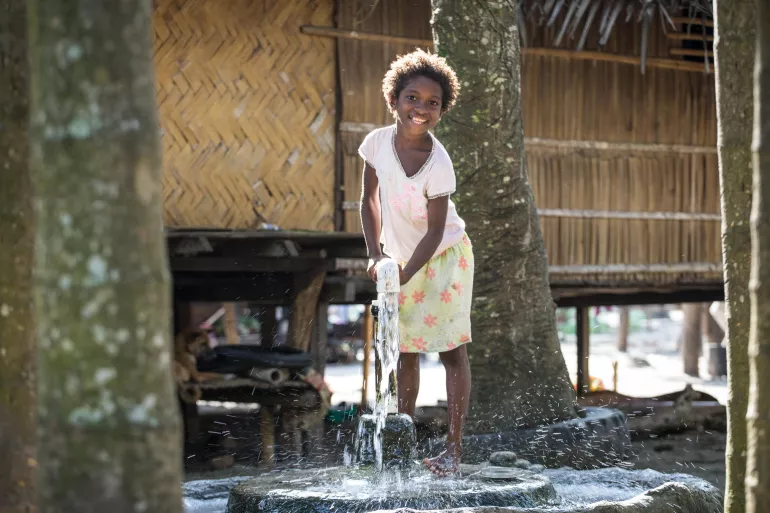 A young girl pumps water from an underground water source at Dugumor Village, Bogia District, Madang Province.